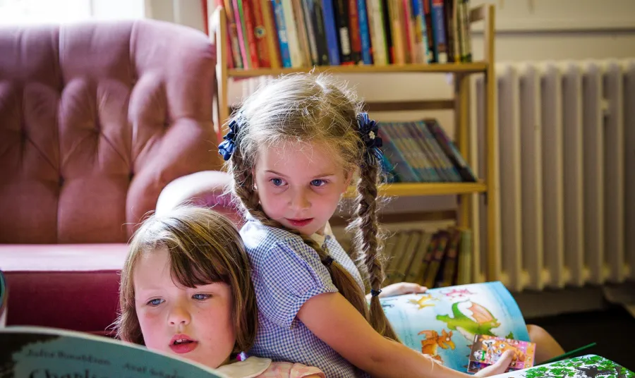 Two children read books as part of a Reader session