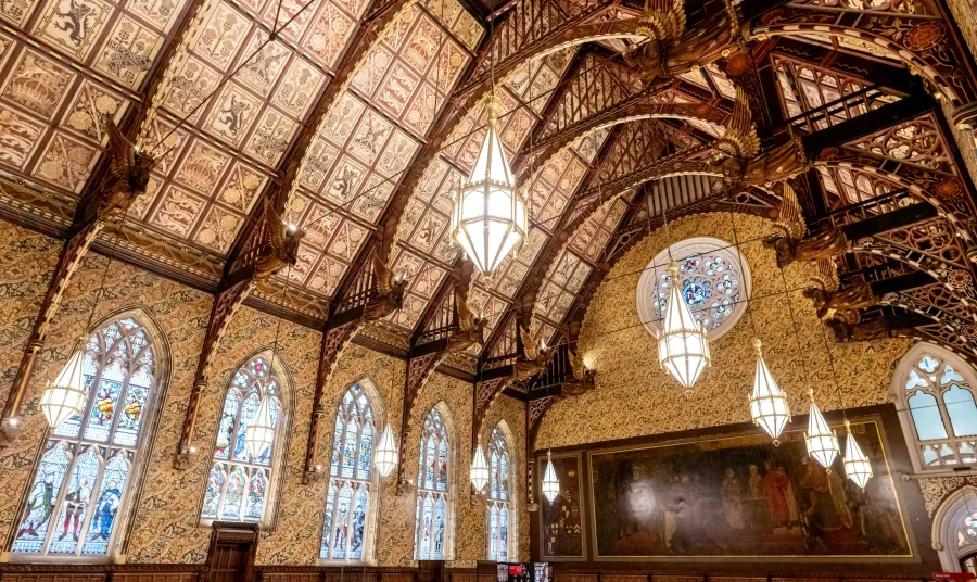 The interior of the Great Hall at Rochdale Town Hall, with decorative ceiling panels and gold angel statues held by wooden beams.