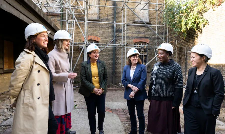 Group of people wearing hard hats in a courtyard of historic building, Alice Billings House in Stratford