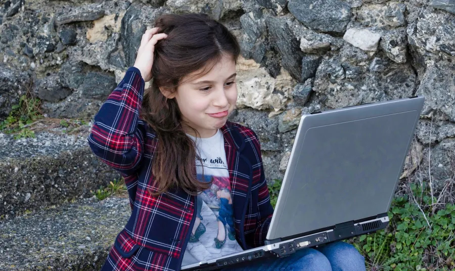 Young person looking at phone on beach