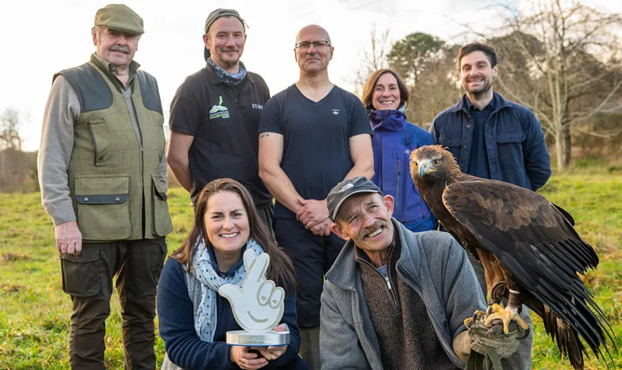 Group of people holding award and an eagle
