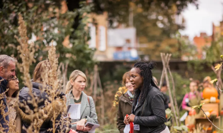 A woman leading a group tour at the Chelsea Physic Garden.