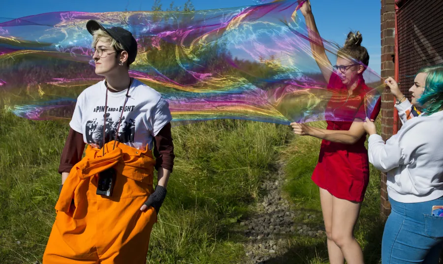 Photoshoot with giant bubbles and three people