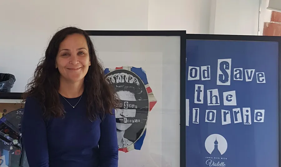 Anne Lundon, Chief Executive of the Florrie, smiles in front of campaign artworks