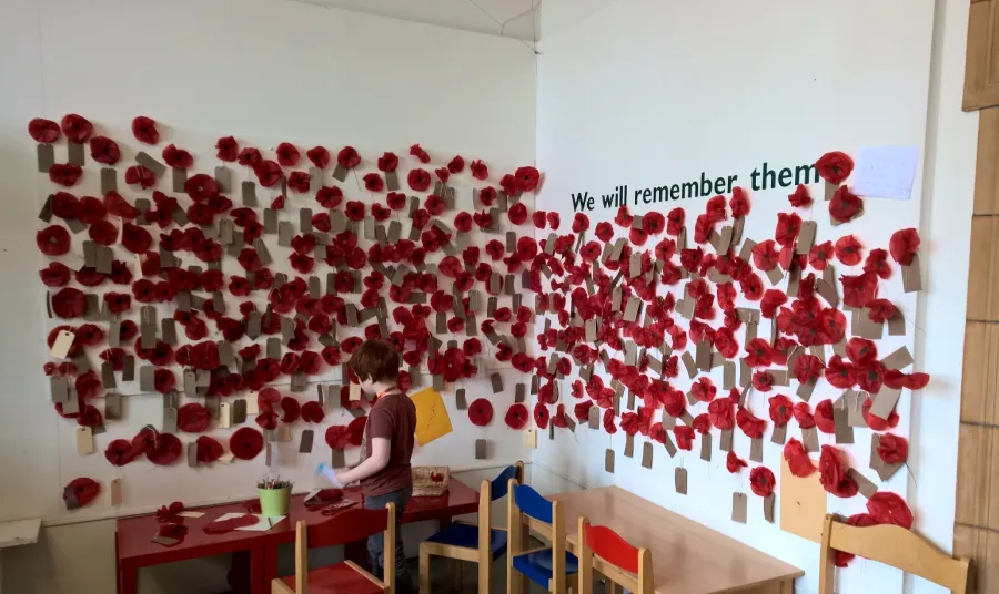 A young visitor adds to the poppy wall of remembrance at Worcester City Art Gallery and Museum