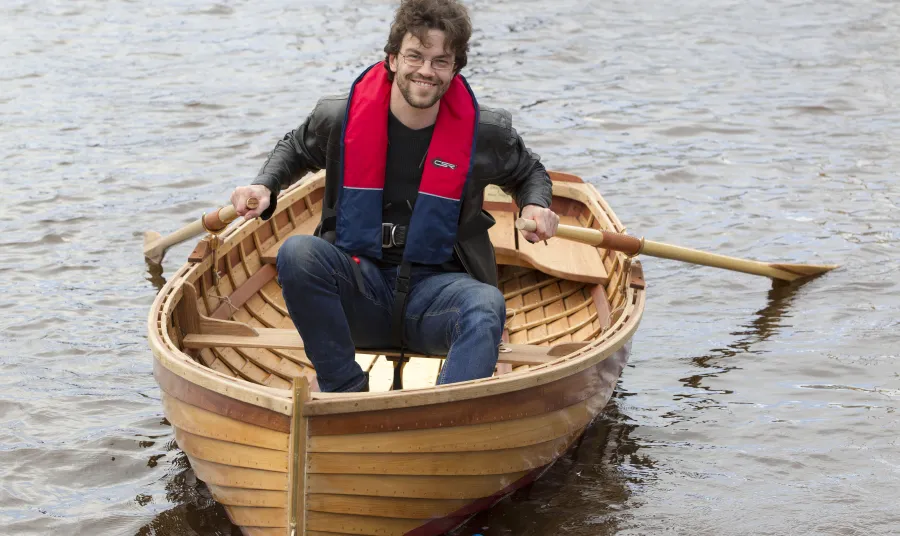 A man in a dinghy on the River Clyde