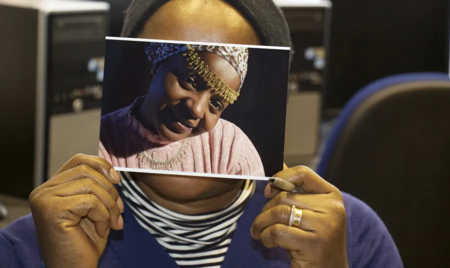 A woman holds a photograph over her face