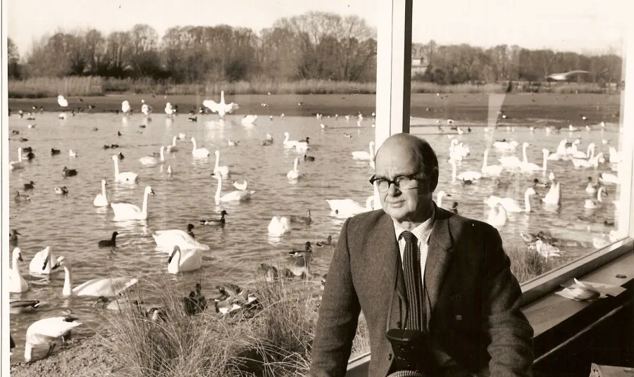 Sir Peter Scott in front of a lake