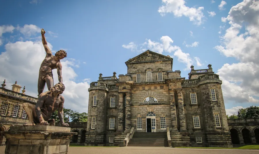 Seaton Delaval Hall, a baroque manor house flanked by elaborate stone statues