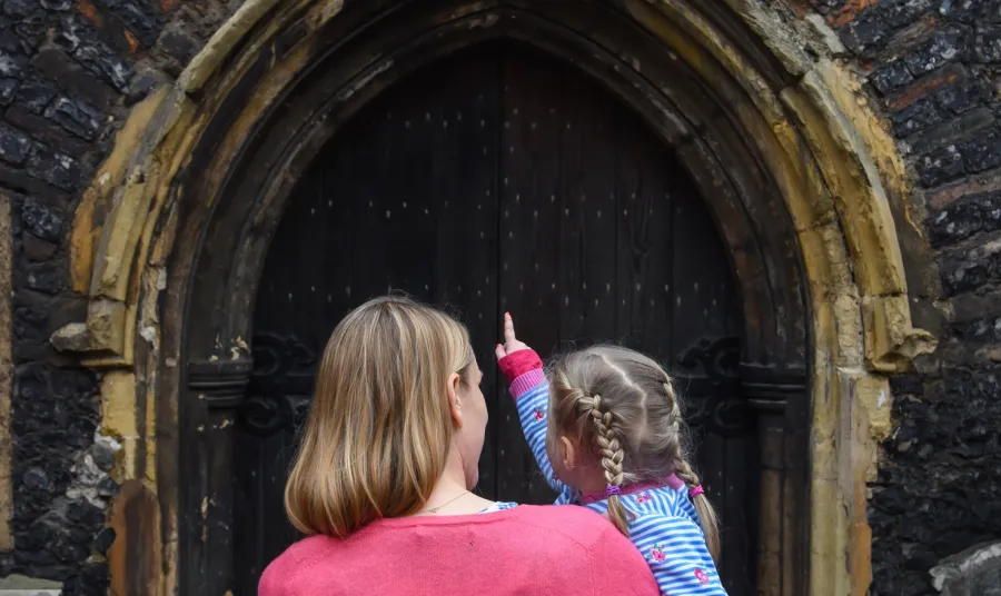 Mother and little girl look at St John Maddermarket Church, Norwich