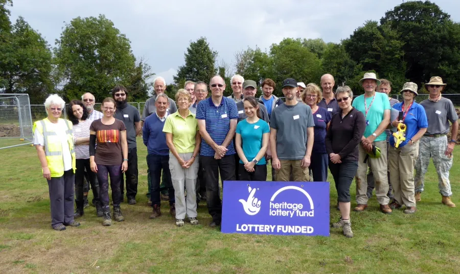 Project helpers next to a National Lottery funded sign