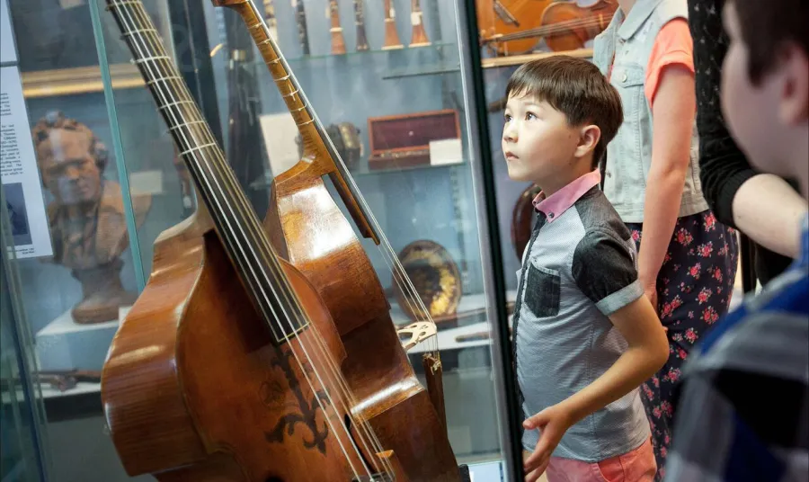 Royal College of Music Museum: child looking at instruments 