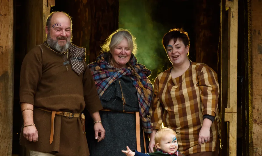A family group in Iron Age dress in the doorway of the round House
