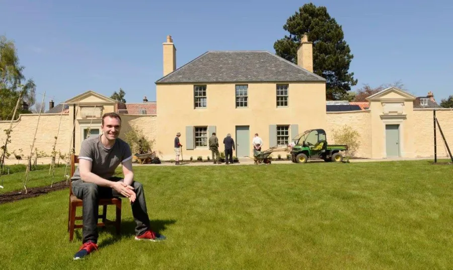 Sutherland Forsyth sitting in front of the Cottage