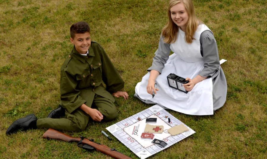 Isaac Khan and Sophie Turbot in period costume with the First World War board game.