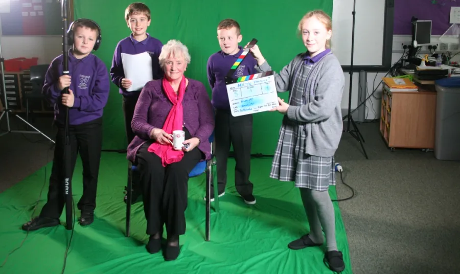 An older woman is interviewed by four children