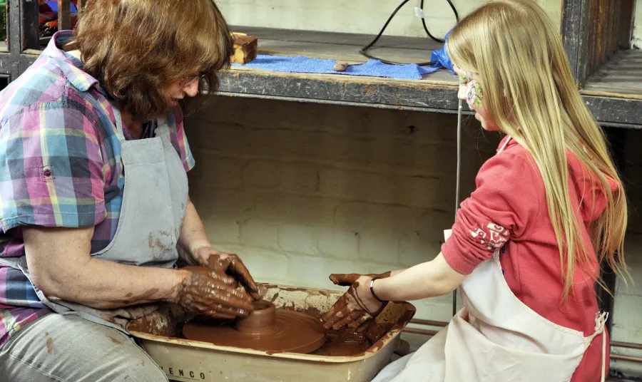 A woman and girl try pottery
