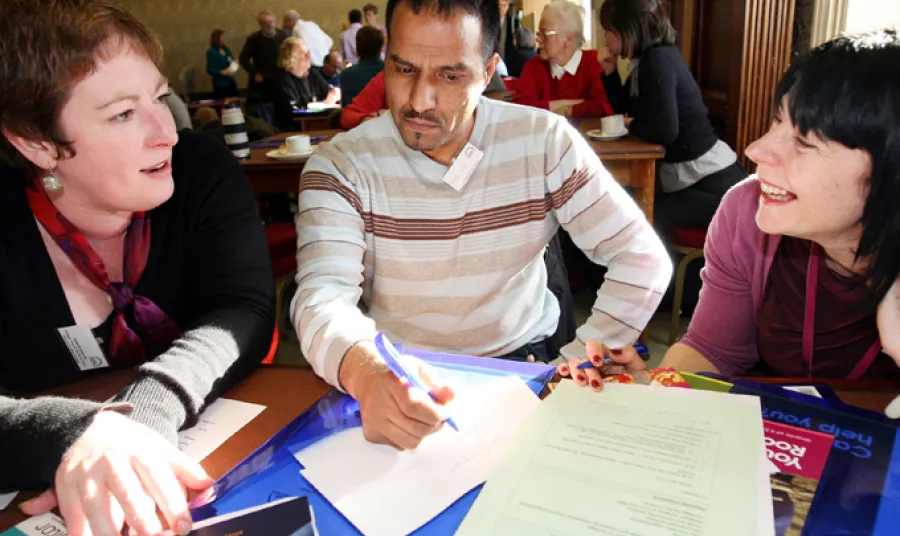 Two women and a man discussing papers