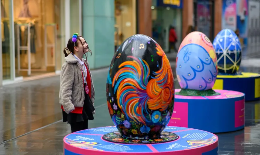 Children stand next to pysanka egg display for Eurovision celebrations