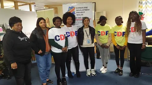 A group of adults posing for the photo, some wearing t-shirts with the CDP logo on the front.