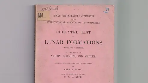 A photograph of a scientific publication titled Collated List of Lunar Formations. The cover page mentions Mary Blagg as the author of the work