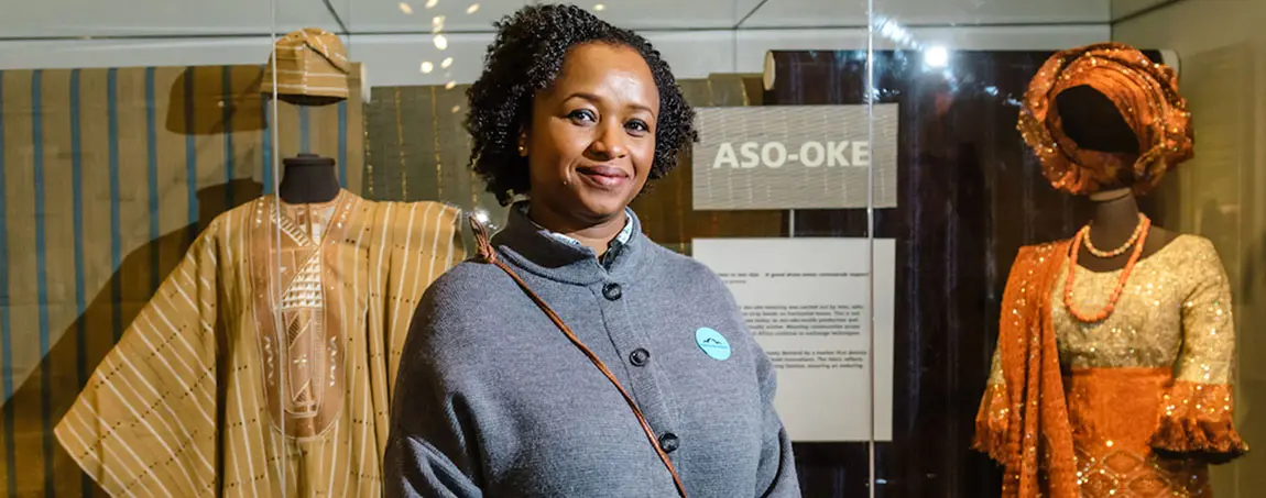A curator in front of a display of African fashion