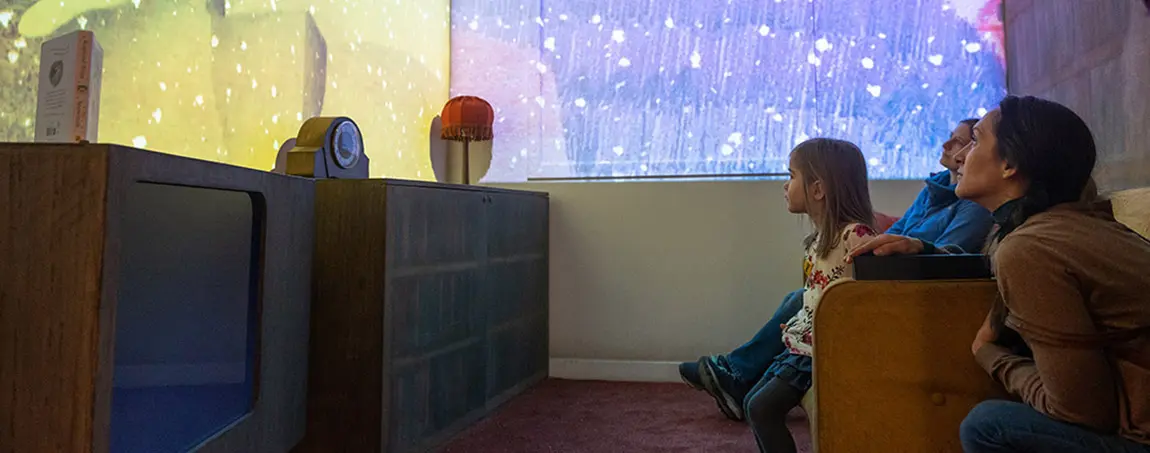 A family watching an animation projected onto a wall