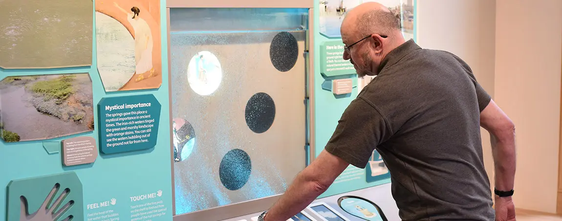 A person engaging with an interactive museum display.