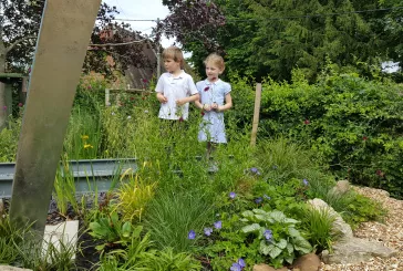 Two children standing amongst nature