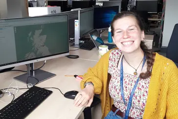 Emma Carroll smiling using computer
