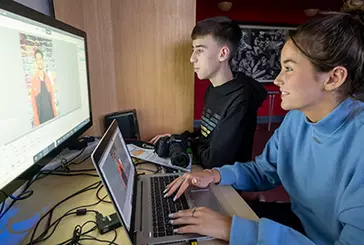 Two young people use a computer