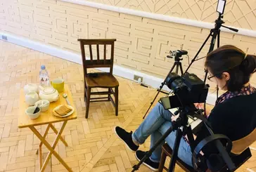 A person sits with a camera ready to record a video interview