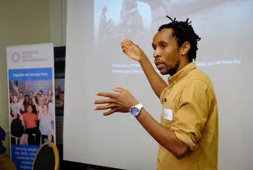 A man is giving a presentation to a room of people.