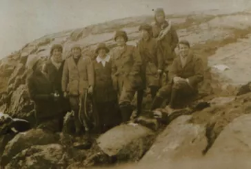 Group of people on mountain pose for camera