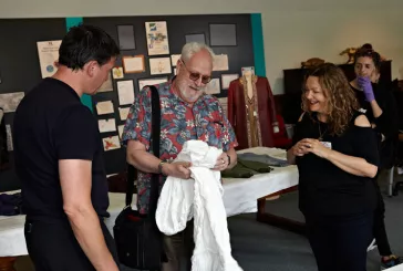 Person holding white top whilst two people look on