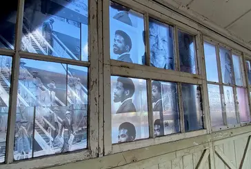 Transparent archive images of the Windrush generation on a series of windows at Tilbury