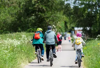 A family cycle on a road on a day out to a heritage site
