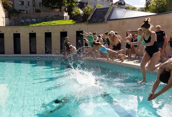 A group of people jump into the newly opened pools on a sunny day