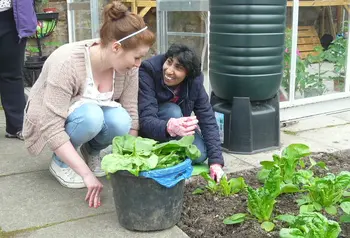 Two people smiling whilst gardening