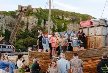 A group of people standing on the deck of a small wooden boat