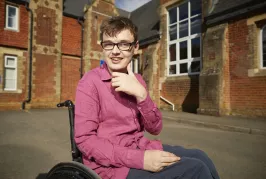 Boy in a wheelchair outside a heritage property