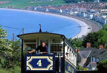 The tram on its way to the summit with a view of a beach below