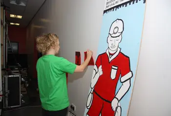 A young person setting up an exhibition for the From Coal to Goal project