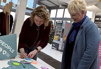 A member of the council team speaks to a member of the community, looking over and annotating a map of the area together.