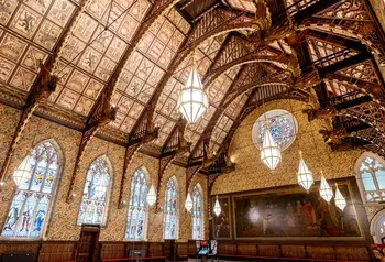 The interior of the Great Hall at Rochdale Town Hall, with decorative ceiling panels and gold angel statues held by wooden beams.
