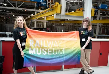 Two people holding a Pride flag