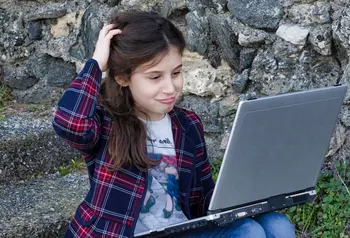 Digital guide: working safely online with children and young people Young person looking at phone on beach