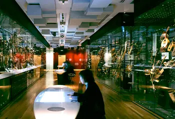 People sitting at tables with modern displays of musical instruments