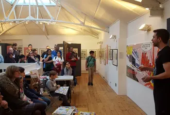 A comic Creator giving a talk in front of a crowd at The Cartoon Museum