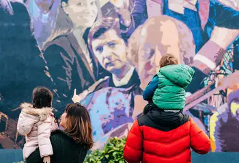 Two adults and two children looking at a wall mural
